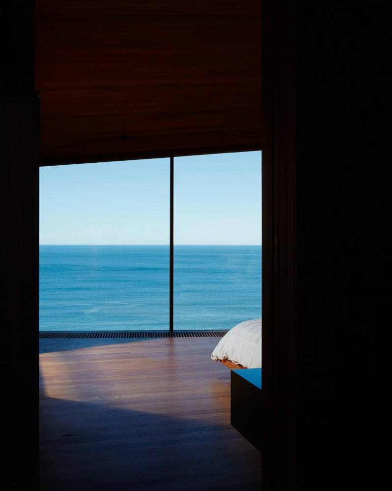 A photo of the sea from a dark room.